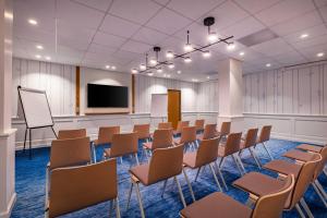 Sala de conferencias con sillas y TV de pantalla plana en Hôtel Arcanse by Inwood Hotels en Arcachon