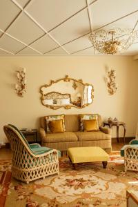uma sala de estar com um sofá e cadeiras e um lustre em Passalacqua em Moltrasio