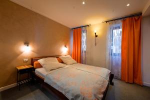 una camera con letto e finestra con tende arancioni di Chesa Arnolongo a Rovigno (Rovinj)