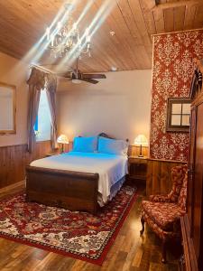 um quarto com uma cama e uma cadeira em The Russ House em Tombstone