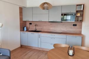 a kitchen with white cabinets and a wooden table at Apartmán Bešeň in Bešeňová
