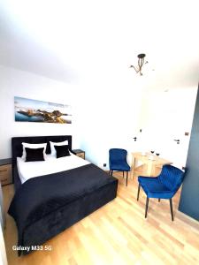 クリニツァ・モルスカにあるWilla Rubin z WIDOKIEM NA ZALEWのベッドルーム1室(ベッド1台、青い椅子2脚付)