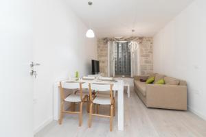 - un salon blanc avec une table et un canapé dans l'établissement 2 bedrooms apartement at Zadar 500 m away from the beach with city view balcony and wifi, à Zadar