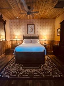 um quarto com uma cama e duas mesas com candeeiros em The Russ House em Tombstone