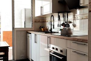 Una cocina con gabinetes blancos y encimera. en Apartamento Picasso, en Salou