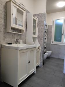 a white bathroom with a sink and a toilet at Braschi 8 B&B in Zola Predosa