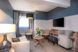 a living room with a couch and a table at Hôtel Arcanse by Inwood Hotels in Arcachon