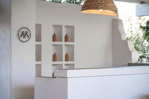 una parete bianca con uno scaffale con dei vasi sopra. di Masseria Li Foggi a Gallipoli