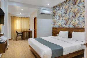ein Schlafzimmer mit einem Bett und einem Wandgemälde in der Unterkunft Omkar Executive in Pune