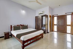 1 dormitorio con 1 cama grande en una habitación en Collection O KMM Kushi Resort, en Gundlupet