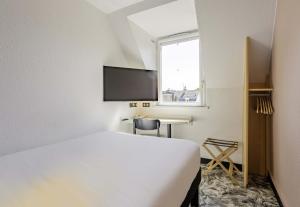 una camera d'albergo con letto e TV di B&B HOTEL Arras Centre Les Places ad Arras