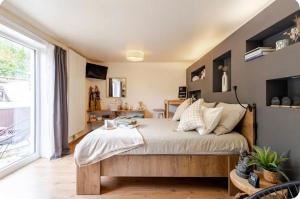 a bedroom with a bed and a large window at Duna - Japandi B&B met topontbijt & wellness in Koksijde