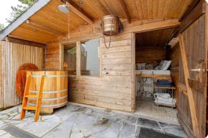 a wooden cabin with a window and a chair at Bed & breakfast Duna met hammam, jacuzzi, sauna in Koksijde
