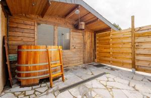 una cabaña de madera con una silla delante en Bed & breakfast Duna met hammam, jacuzzi, sauna en Koksijde