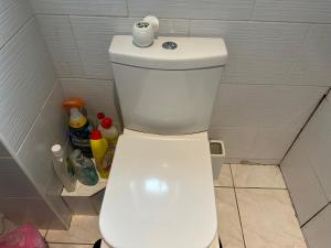 a toilet with a roll of toilet paper on top of it at Home Away From Home in Plumstead
