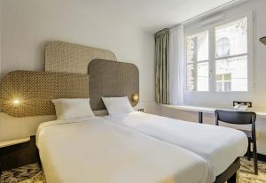 B&B HOTEL Arras Centre Les Places في أراس: غرفة نوم مع سرير أبيض كبير مع نافذة