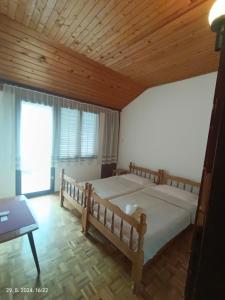 a bedroom with a large bed and a wooden ceiling at Privatan smeštaj Igalo in Igalo