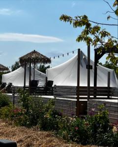 uma tenda com cadeiras e guarda-sóis num jardim em Vättervy Glamping em Habo