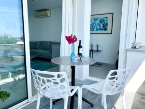a table with two chairs and a vase with flowers at Vistas Del Mar by Hello Homes Sitges in Sitges
