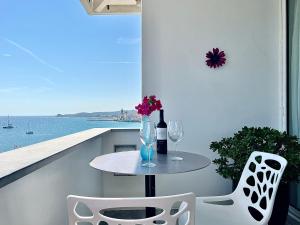 a table and chairs on a balcony with a view of the ocean at Vistas Del Mar by Hello Homes Sitges in Sitges