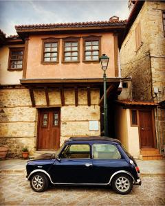 una macchina blu parcheggiata di fronte a una casa di Aristotelous Alexandrou Historic Inn a Arnaia