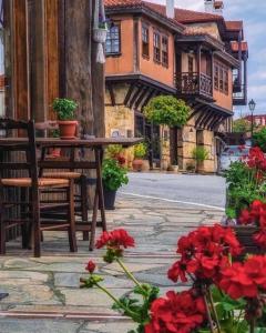 奧納亞的住宿－Aristotelous Alexandrou Historic Inn，大楼前的桌子、椅子和鲜花