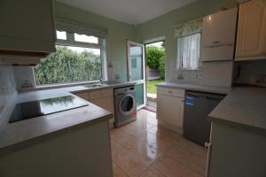 een keuken met een wastafel en een wasmachine bij Llewnodeb in Belvedere
