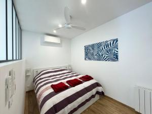 1 dormitorio con 1 cama y una pintura en la pared en Appartement 1ch avec terrasse et jardinet à 400m de la plage, en Cavalaire-sur-Mer