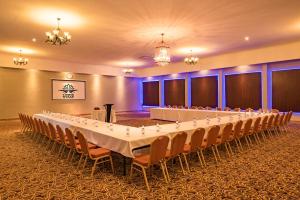 uma sala de conferências com uma mesa longa e cadeiras em Lotus by Serendib em Blantyre