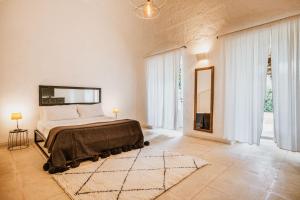 1 dormitorio con cama y ventana grande en Masseria Li Foggi, en Gallipoli