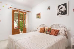 a white bedroom with a large white bed with pillows at La Casa del Far in Alcanada