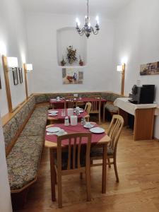 Gästehaus Einzinger في كريمس ان دير دوناو: غرفة طعام مع طاولة وكراسي وبيانو