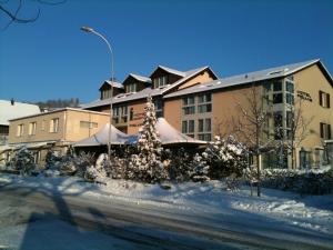 un edificio con un árbol de Navidad en la nieve en Hotel Felmis, en Lucerna