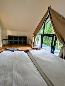 1 dormitorio con 2 camas y ventana grande en Kaletka - cisza i przyroda en Iława