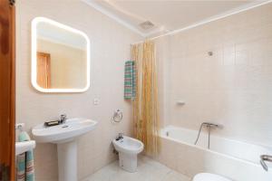 a bathroom with a sink and a toilet and a mirror at La Casa del Far in Alcanada