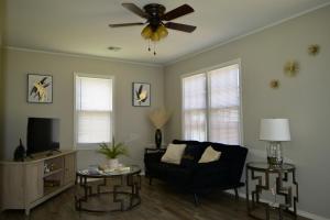 Modern Comforts/7minTo Downtown في مدينة اوكلاهوما: غرفة معيشة مع أريكة ومروحة سقف