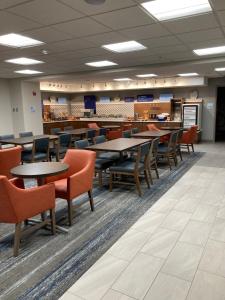une salle à manger avec des tables et des chaises dans un bâtiment dans l'établissement Holiday Inn Express - Akron NW - Fairlawn, an IHG Hotel, à Akron
