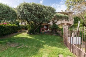 a house with a fence and a tree in a yard at La Casa del Far in Alcanada