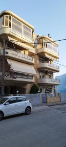 a white car parked in front of a building at MV LUX Apartment in Alexandroupoli