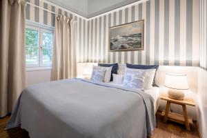 ein Schlafzimmer mit einem großen Bett mit blauen und weißen Streifen in der Unterkunft Schloss Hertefeld & Hertefeldhof in Weeze