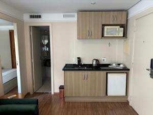 a small kitchen with a sink and a microwave at HOTEL SHOPPING VILA OLIMPIA in Sao Paulo