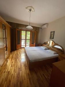 1 dormitorio con 1 cama grande y suelo de madera en Exohi apartments, en Vrasná