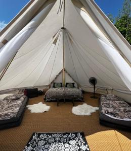 uma tenda com duas camas e almofadas no chão em Vättervy Glamping em Habo