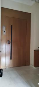 una puerta marrón con un cartel en un edificio en Vik Apartment en Alejandrópolis