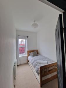 1 dormitorio con cama y ventana en Lovely 3 bedroom Whitley Bay Townhouse., en Whitley Bay