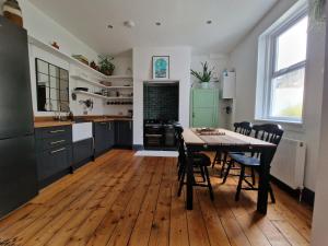 een keuken met een tafel en stoelen in een kamer bij Lovely 3 bedroom Whitley Bay Townhouse. in Whitley Bay