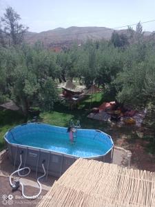 a woman in a swimming pool in a yard at Les délices d Aya in Tahannout