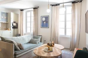 Una sala de estar con un sofá azul y una mesa. en SAINTE ANNE by Time Off Collection, en Saint-Tropez