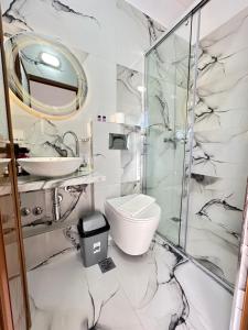 La salle de bains est pourvue de toilettes et d'une douche en verre. dans l'établissement Eleni Guest House, à Saranda