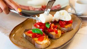 a plate of food with toast with tomatoes and cheese at Palazzo Zacà in Gallipoli